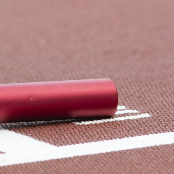 Metallic red baron laying on running track - close-up